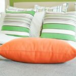Farben und Muster: Oranges Kissen, karierte und gestreifte Kissen (de.depositphotos.com)