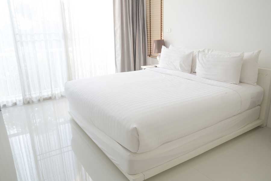 Bett mit passender Matratze und weißer Bettwäsche (de.depositphotos.com)